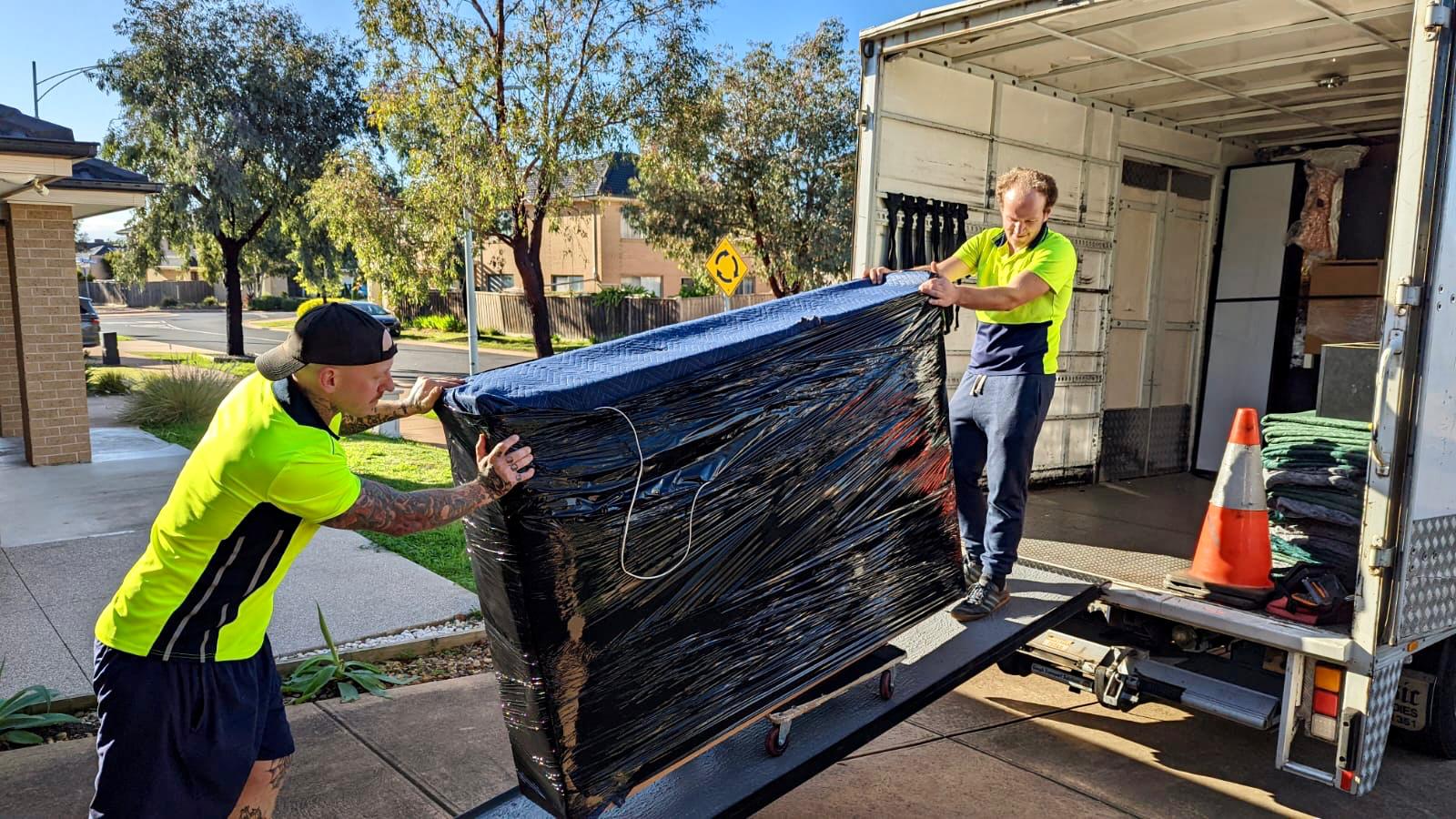 TCB Removals Melbourne movers carefully loading protected furniture and goods with truck ramp